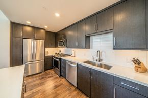 San Diego apartment for rent - A modern kitchen with dark wood cabinets and stainless steel appliances.