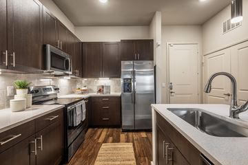 Richardson apartment for rent - A kitchen with dark wood cabinets and stainless steel appliances.