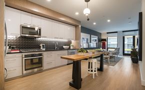 San Diego apartment for rent - a kitchen and dining room with white cabinets and a wooden table