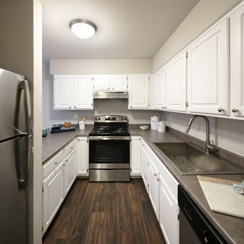 Stainless steel appliances including refrigerator, electric range, and dishwasher