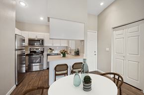Tempe apartment for rent - an open kitchen and dining room with stainless steel appliances and a white table