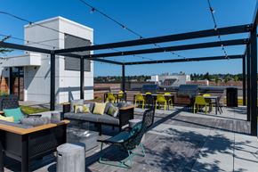 Seattle apartment for rent - a rooftop patio with tables and chairs and a canopy