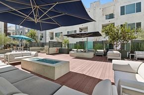Long Beach apartment for rent - A patio with a pool and chairs under a blue umbrella.