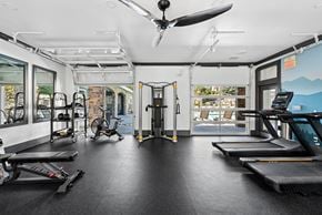 Aurora apartment for rent - A gym with treadmills, exercise bikes, and a fan.