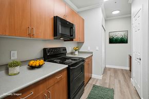 Tracy apartment for rent - A kitchen with wooden cabinets and a black stove top oven.