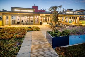 Seattle apartment for rent - A modern building with a wooden walkway in front of it.