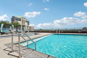 Denver apartment for rent - A swimming pool with a metal ladder and a building in the background.