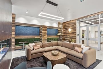 Vancouver apartment for rent - A modern living room with a large sectional sofa and a fireplace.