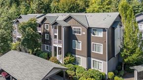 Renton apartment for rent - A large building with a grey roof surrounded by trees.