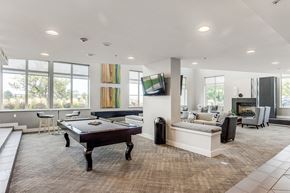 Denver apartment for rent - A billiard table is in the middle of a spacious room with a couch and a television.