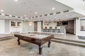 Denver apartment for rent - A pool table is in the middle of a room with a bar in the background.