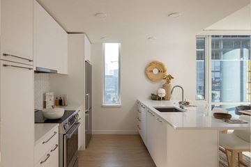 Seattle apartment for rent - A modern kitchen with white cabinets and a wooden floor.