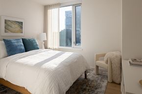 Seattle apartment for rent - a bedroom with a bed and a large window
