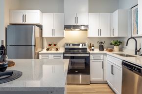 Mukilteo apartment for rent - a kitchen with white cabinets and stainless steel appliances