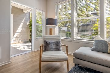Mukilteo apartment for rent - a living room with a chair and a lamp and windows