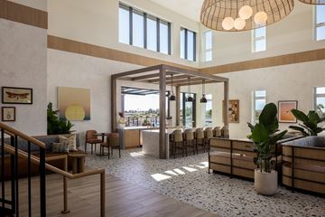 Huntington Beach apartment for rent - A large, open-plan living space with a staircase on the left and a long row of chairs on the right.
