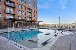 Denver apartment for rent - A pool with a diving board in front of a building.