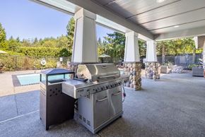 Renton apartment for rent - A BBQ grill is on a patio with a pool in the background.