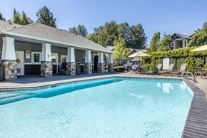Renton apartment for rent - A large swimming pool in front of a building with a covered patio area.