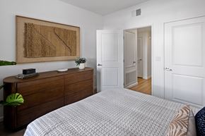 Vista apartment for rent - A bedroom with a large bed and a wooden dresser.
