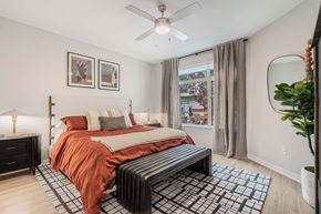 Denver apartment for rent - A bedroom with a bed, nightstand, and a window with curtains.