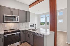 Denver apartment for rent - A kitchen with a white counter top and dark brown cabinets.