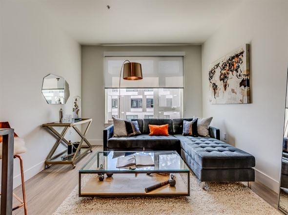 Seattle apartment for rent - A modern living room with a black sofa and a glass coffee table.