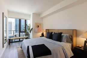 San Diego apartment for rent - A bedroom with a large bed and a view of the city.