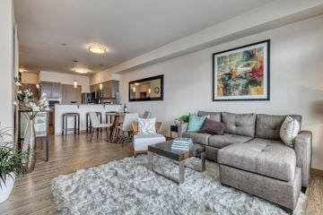 Bothell apartment for rent - A living room with a grey couch, a coffee table, and a painting on the wall.