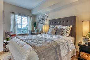 Bothell apartment for rent - A bedroom with a large bed and a window with curtains.