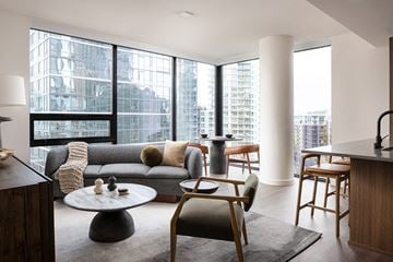 Seattle apartment for rent - A modern living room with a grey sofa and a large window.