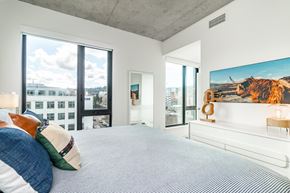 Portland apartment for rent - A bedroom with a large bed and a painting of a cow on the wall.