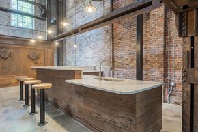 Seneca apartment for rent - a kitchen with exposed brick walls and a bar with stools