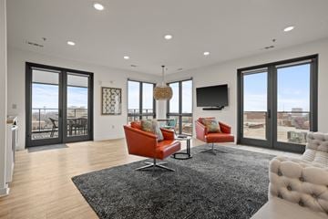 Spartanburg apartment for rent - A modern living room with a black rug and red chairs.