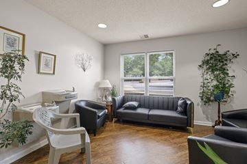 Travelers Rest apartment for rent - A living room with a black couch and a white chair.