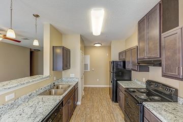 Kings Mountain apartment for rent - A kitchen with a black refrigerator and stove top oven.
