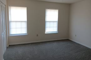 York apartment for rent - an empty room with two windows and a carpet