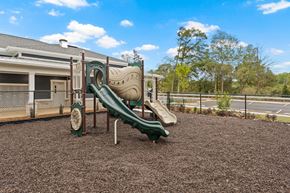 Greenville apartment for rent - A playground with a green slide and brown ground.