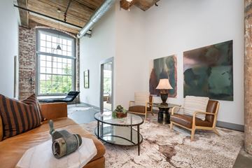 Spartanburg apartment for rent - A living room with a brown leather couch and a glass coffee table.