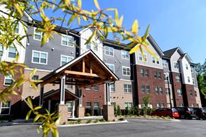 Greenville apartment for rent - A large multi-story apartment building with a covered walkway.