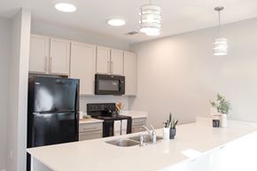 Spartanburg apartment for rent - A kitchen with black appliances and white countertops.