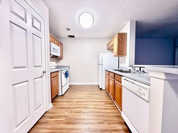 Beaufort apartment for rent - A kitchen with white cabinets and a wooden floor.
