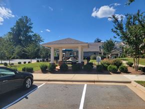 Mocksville apartment for rent - A black car is parked in a parking lot in front of a building with a covered walkway.