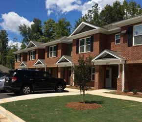 Orangeburg apartment for rent - A black SUV is parked in front of a brick house with the number 150 on the front door.