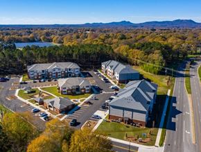 Gastonia apartment for rent - A large building complex with a parking lot in front of it.