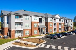 Gastonia apartment for rent - A large apartment complex with a parking lot in front.