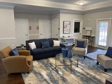 Gastonia apartment for rent - A living room with a black couch and a glass coffee table.