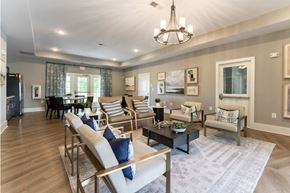 Greenville apartment for rent - A well-lit living room with a variety of seating options and a chandelier.