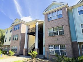 Beaufort apartment for rent - A two-story brick apartment building with a garage door open.