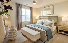 Calabash apartment for rent - A bedroom with a large bed and a vase on the side table.